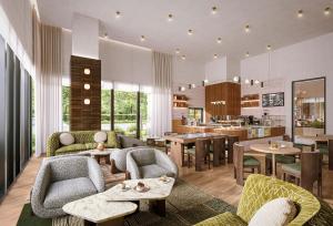 a living room with chairs and tables and a kitchen at Denu Hotel & Spa in Phoenix