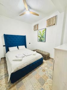 a bedroom with a blue bed and a ceiling fan at VENICE by luxury Atitlan in San Pedro La Laguna