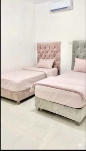 two beds in a white room with pink pillows at Loft shaula in Tapachula +40 photos