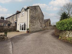 an old stone house with a driveway at Tram Lane Cottage in Carnforth