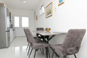 a kitchen with a table and four chairs at House Ratac in Bol