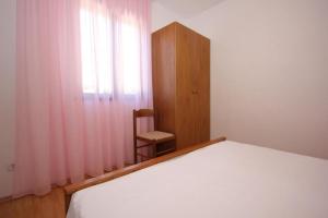 a bedroom with a bed and a chair next to a window at House Paulo1 in Rogačić