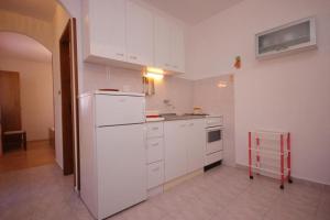 a kitchen with white cabinets and a white refrigerator at House Paulo1 in Rogačić