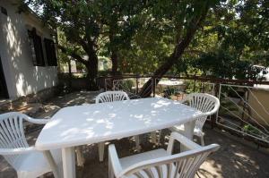 a white table and white chairs on a patio at House Paulo2 in Rogačić