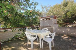 a table with four chairs and a pizza oven at House Paulo2 in Rogačić