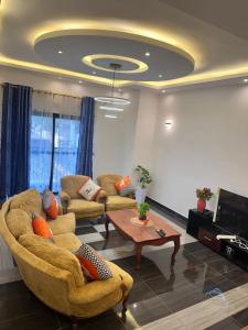 a living room with two couches and a tv at Résidence Prestige KGV Appt 303 in Douala