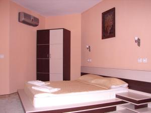a bedroom with a bed and a cabinet at Hotel Amfibia in Primorsko
