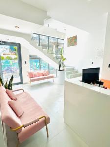 a living room with pink furniture and a staircase at NEW YORK by luxury atitlan in San Pedro La Laguna