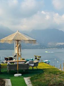 two benches sitting under an umbrella on a hill at NEW YORK by luxury atitlan in San Pedro La Laguna
