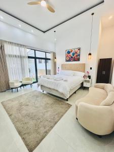 a bedroom with a large bed and two chairs at NEW YORK by luxury atitlan in San Pedro La Laguna