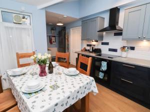 a kitchen with a table with a vase of flowers on it at Riverside Cottage in Warkworth