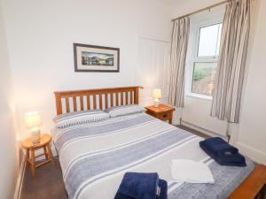 a bedroom with a large bed and a window at Riverside Cottage in Warkworth