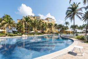 a swimming pool at a resort with palm trees at Exclusive Oceanfront Apartment Beach access in Acapulco