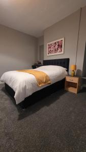 a bedroom with a large bed and a night stand at Central Guest House in Newport