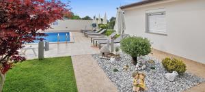a backyard with a garden with tables and umbrellas at Villa Kasandra - Ruhe & Eleganz in Buje, Istrien in Kaštel