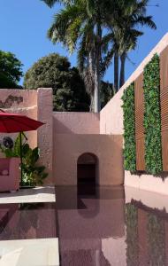 a retaining wall with a bench and palm trees at Cuna 58 in Barranquilla