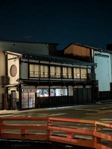 a building with a fence in front of it at night at Daihachi in Takayama