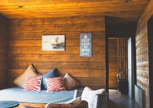 a bedroom with wooden walls and a bed with pillows at Cabañas Mirador de Matanzas in Matanzas