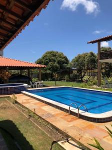 a large swimming pool in a yard with a house at Espaço Ybirá in Marechal Deodoro