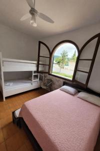 a bedroom with a bed and a large window at Casa da Edna in Guarujá +42 photos