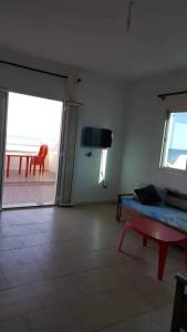 a living room with a couch and a table and a television at V résidence in Ḩamādat al Kebalou +10 photos
