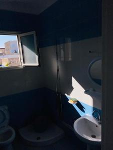 a bathroom with a sink and a toilet and a window at V résidence in Ḩamādat al Kebalou