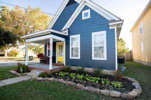 a blue house with a flower bed in the front yard at Memphis Charm in Memphis