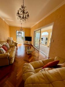 a living room with couches and a chandelier at Casa Neves in Arco da Calheta