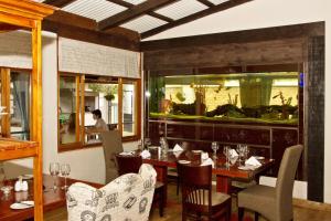 a restaurant with a table and chairs and a fishtank at Casa Forno Country Hotel in Otjiwarongo +37 photos
