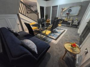 a living room with a blue couch and a table at Charming Tudor Cottage White House Free Wifi Manchester in Manchester