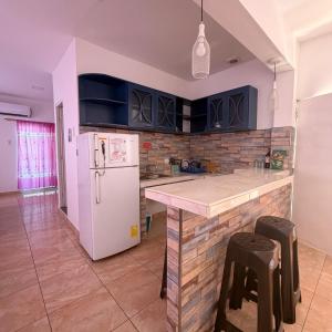 a kitchen with blue cabinets and a white refrigerator at Preciosa Suite Familiar para 10 personas con cocina y 3 piscinas in Playas