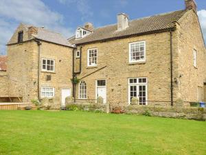 a large brick building with a large grass yard at The Lodge in Snainton