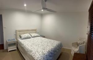 a bedroom with a bed and a ceiling fan at Byron Beach Cabin in Byron Bay