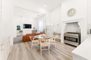 a kitchen and living room with a table and chairs at Belle Escapes - The Light House in Glenelg