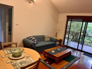 a living room with a table and a couch at Byron Beach Cabin in Byron Bay