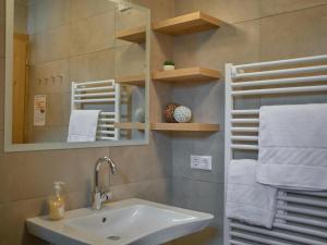a bathroom with a sink and a mirror and towels at BergbiberHAUS Top A in Piesendorf +22 photos