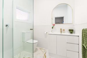 a bathroom with a shower and a toilet and a mirror at Belle Escapes - The Light House in Glenelg +31 photos