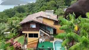 a house on top of a hill with trees at Chale Tupi da Pedra in Trindade