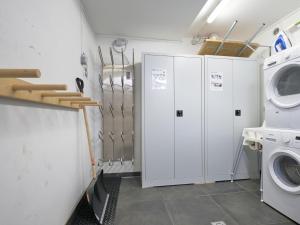 a laundry room with white cabinets and a washer and dryer at BergbiberHAUS XL in Piesendorf