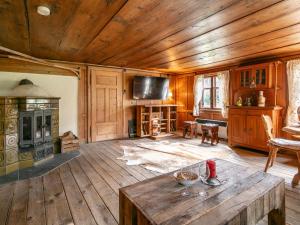 a living room with a wooden ceiling and a table at Waldhüsle in Dalaas