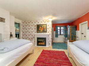 a bedroom with two beds and a fireplace at Waldhüsle in Dalaas