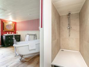 a bathroom with a white tub and a shower at Waldhüsle in Dalaas +35 photos