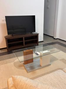 ein Wohnzimmer mit Fernseher und Couchtisch in der Unterkunft Come chez soi in Abidjan