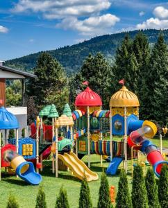 a playground with a slide and a play structure at Apartamenty koło Szczyrku A&S Spa - basen, jacuzzi, sauna in Szczyrk