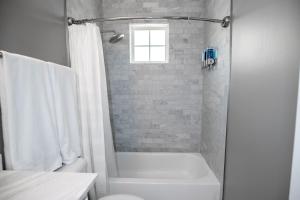 a white bathroom with a shower and a toilet at Memphis Charm in Memphis +24 photos