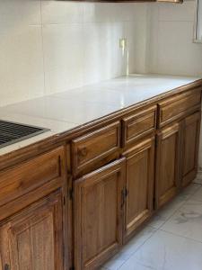 a kitchen with wooden cabinets and a counter top at VIP Hotel Haiti in Port-de-Paix