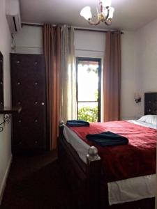 ein Schlafzimmer mit einem roten Bett und einem Fenster in der Unterkunft Al Midan Hotel in Amman