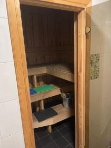 a wooden cabinet with shelves in a bathroom at Pusa Saunamaja in Jõhvi