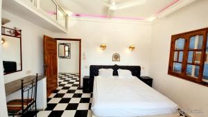 a bedroom with a bed and a checkered floor at Villas calme et sans vis-à-vis proche de la plage Tezdaine in Midoun
