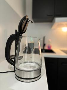 a tea kettle sitting on a counter with water in it at MoonGreen - EuroAirport - Basel - HighQuality in Saint-Louis